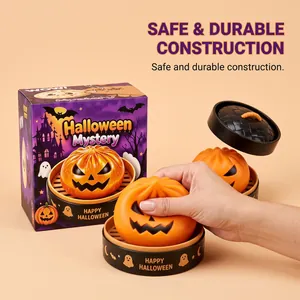 Macro shot of a hand squeezing a soft pumpkin-shaped Halloween squishy toy.