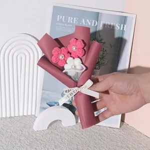 Vista dettagliata di un mini bouquet di fiori all'uncinetto fatti a mano rosa e bianchi