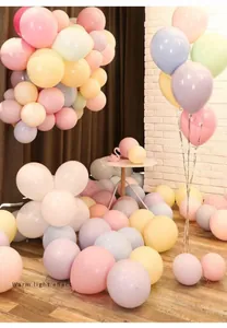 Dettaglio di palloncini macaron pastello sotto luce calda per decorazioni.