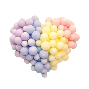 Palloncini pastello macaron colorati disposti a forma di cuore per decorazioni festa.