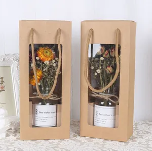 Elegante Kraftpapier-Geschenkboxen mit Trockenblumen-Glasflaschen auf weißer Spitze