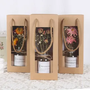 Detailansicht von drei Kraftpapiertüten mit Trockenblumen in Glasflaschen