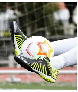 Close-up of professional soccer shoes with vibrant yellow and black stripe patterns.