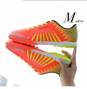 Detailed side view showing orange and yellow TF soccer shoes for men and youth players