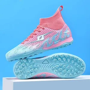 Detailed view of pink and blue high-top soccer cleats featuring TF studded turf outsoles
