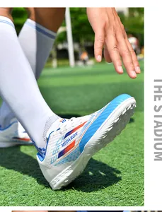 Close-up of colorful white and blue soccer shoes with durable long studs on turf.