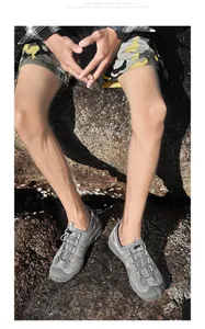 Vue détaillée de chaussures de plein air grises respirantes pour hommes sur rochers