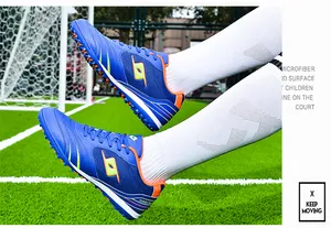 Blue TF soccer shoes on grass field showing non-slip sole and microfiber surface