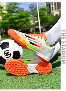 Detailed view of colorful TF soccer shoes with breathable mesh and MEDARON branding.