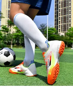 Detail of breathable soccer cleats with colorful accents and turf studs on grass field.