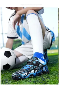 Close-up detail of boys' fleece-lined turf soccer shoes on field with soccer ball