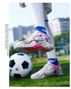 Detail view of children's soccer shoes with warm pink fleece lining and TF soles.