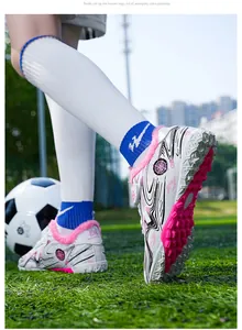 Close-up detail of children's white fleece-lined soccer shoes with pink turf cleats