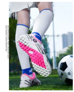 Detail view of children's fleece-lined soccer shoes showing durable pink and white turf sole
