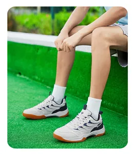 Chaussures de badminton professionnelles blanches et bleues portées sur un terrain