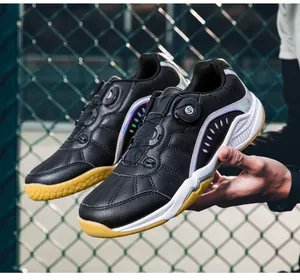 Gros plan de chaussures de badminton noires avec semelles jaunes antidérapantes et lacet rotatif
