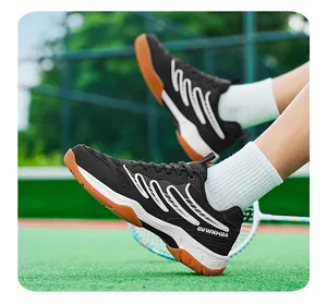 Baskets de badminton noires professionnelles pour hommes sur un fond de court vert sport
