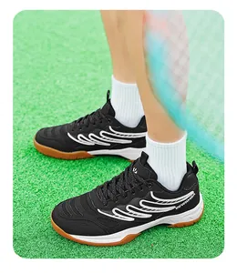Vue détaillée de chaussures de badminton noires pour hommes sur gazon synthétique.