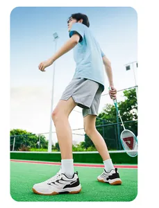 Vue de côté de chaussures de badminton blanches pour hommes sur un terrain extérieur