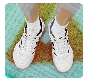 Chaussures de badminton blanches pour hommes avec mesh respirant et semelle en gomme.