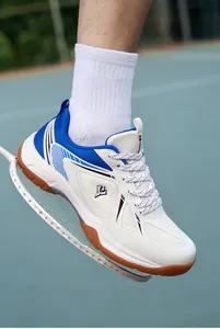 Gros plan d'une chaussure de badminton pro blanche et bleue avec semelle en gomme.