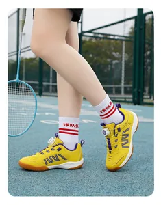 Detail of breathable yellow children's badminton shoes with a rotating dial buckle.