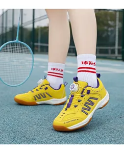 Detail view of yellow breathable badminton shoes for kids featuring a rotary dial lacing system