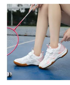 Actiefoto van lichte badmintonschoenen voor meisjes in roze en wit op het blauwe veld