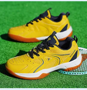 Gros plan de chaussures de badminton respirantes jaune et bleu sur un gazon synthétique.