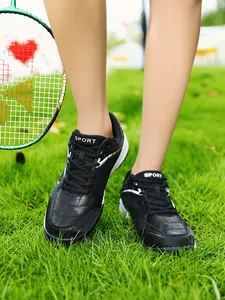 Detailed view of black badminton shoes for men and juniors on green outdoor grass