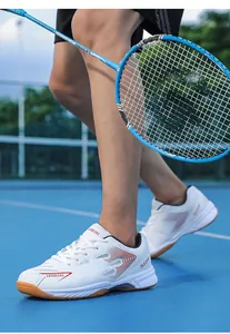 Action detail of professional white badminton shoes with breathable mesh and red accents