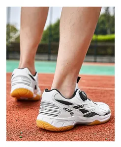 Detailed view of white badminton shoes with dial lacing and gum sole on court
