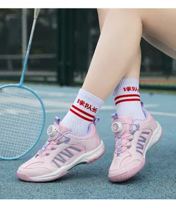 Detailed shot of pink kids badminton shoes with adjustable rotary buckle worn on sport court