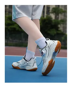 Detail view of professional white children's badminton shoes with rotary dial on court