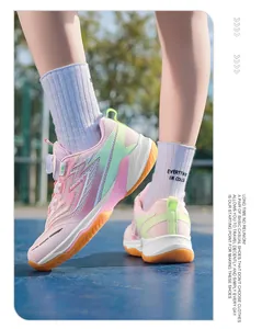 Close-up side view of pink and green kids' badminton shoes featuring non-slip gum soles.