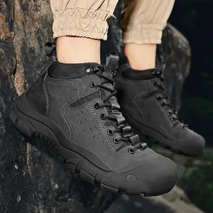 Professional men's mid-top outdoor hiking boots with non-slip rubber soles on rocks.