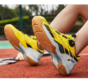 Detail view of yellow badminton shoes with honeycomb grip sole on a red court