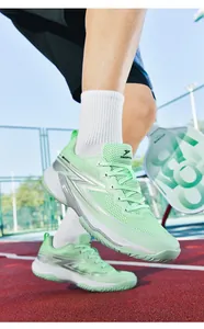Close-up of mint green breathable pickleball shoes on a red and blue outdoor sports court.