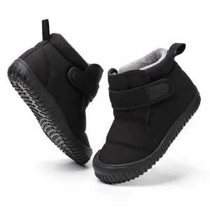 Gros plan de bottes de neige noires pour enfants avec doublure pelucheuse et scratch