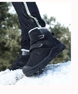 Detail of black children's winter snow boots with warm fur lining in outdoor snow scene
