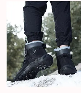 Close-up of children's black high-top snow boots with fur lining walking in snow