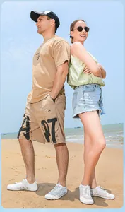 Männliche und weibliche Models tragen weiße Zehenschuhe an einem Sandstrand