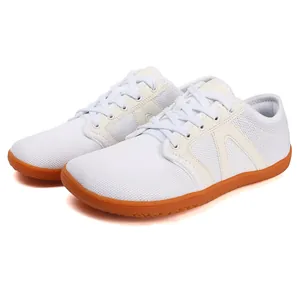 Seitenansicht weißer atmungsaktiver Barfußschuhe mit orangefarbener Gummisohle