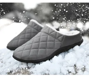 Chaussons d'hiver matelassés gris avec doublure polaire chaude sur fond de neige