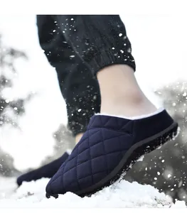 Pantoufles d'hiver matelassées bleu marine avec une doublure en polaire blanche dans la neige