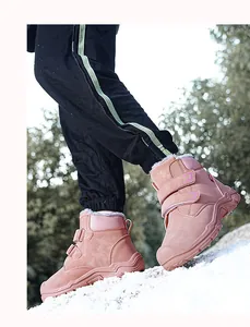 Outdoor view of children's pink thermal snow boots with plush lining on snowy ground