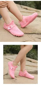 Pink breathable mesh outdoor water shoes for children in a natural rocky environment.