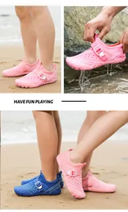 Detail view of children's pink and blue breathable mesh water shoes on a sandy beach