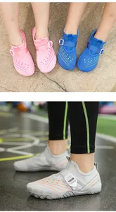 Detail view of grey breathable water shoes for kids with orange stripes and buckle strap.