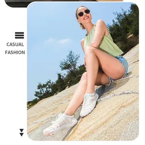 Weiße Outdoor-Watschuhe an einem felsigen Strand im lässigen Modestil getragen